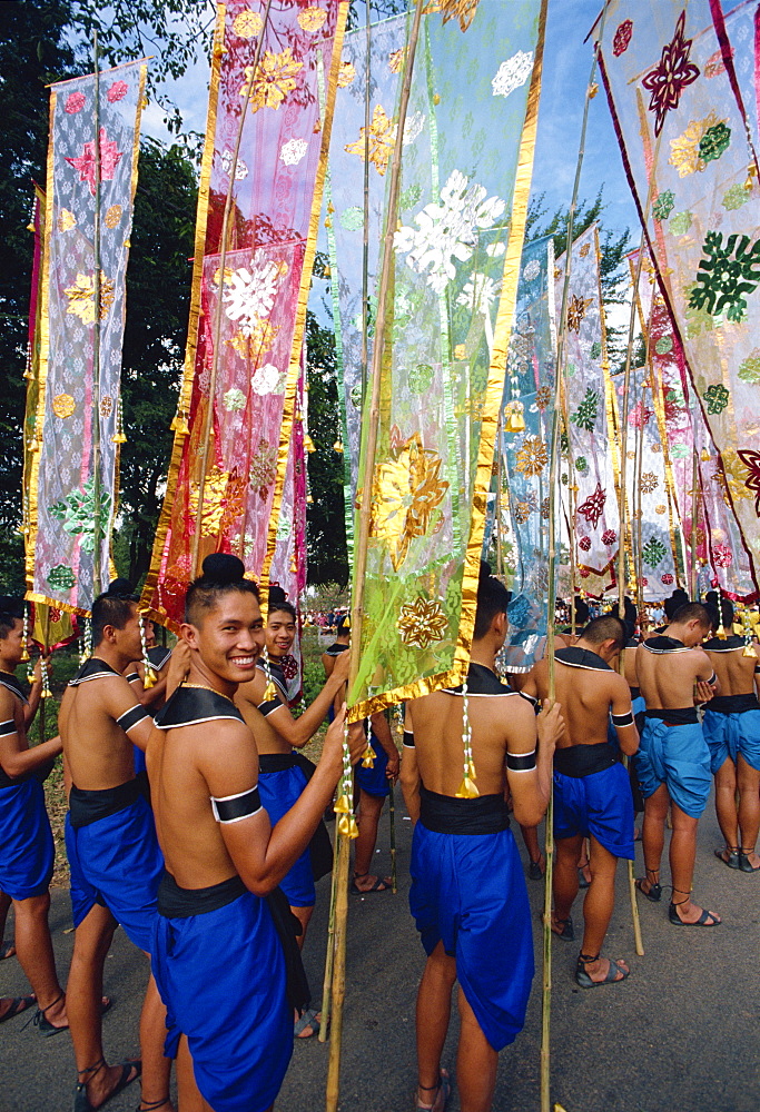 Portrait of a smiling man in a parade of colourful flags during the festival of Loy Krathong at Sukhothai, Thailand, Southeast Asia, Asia