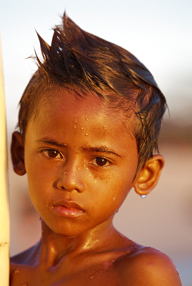 Portrait of a boy with a wet face after learning to surf at Kuta Beach, Bali, Indonesia, Southeast Asia, Asia