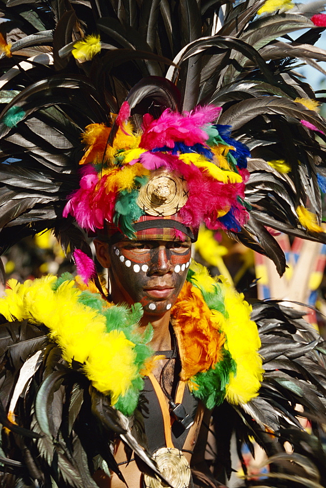 Portrait of a man with facial decoration and head-dress with feathers at Mardi Gras carnival, Dinagyang in Iloilo City on Panay Island, Philippines, Southeast Asia, Asia