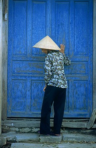 Elderly women wearing traditional hat, against door, Hou An, Vietnam, Indochina, Southeast Asia, Asia