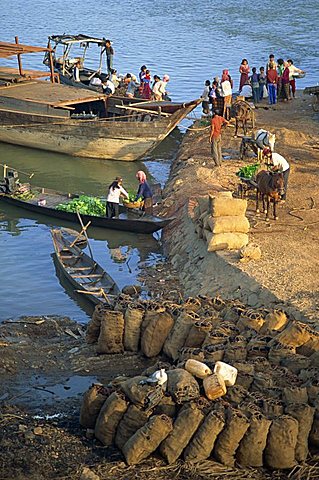 Bags of coal on the shore and boats in the background at Stung Treng, Cambodia, Indochina, Southeast Asia, Asia