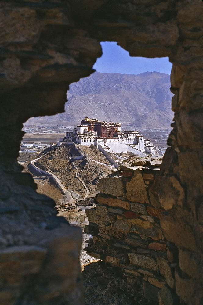 Potala Palace, UNESCO World Heritage Site, seen through ruined fort window, Lhasa, Tibet, China, Asia