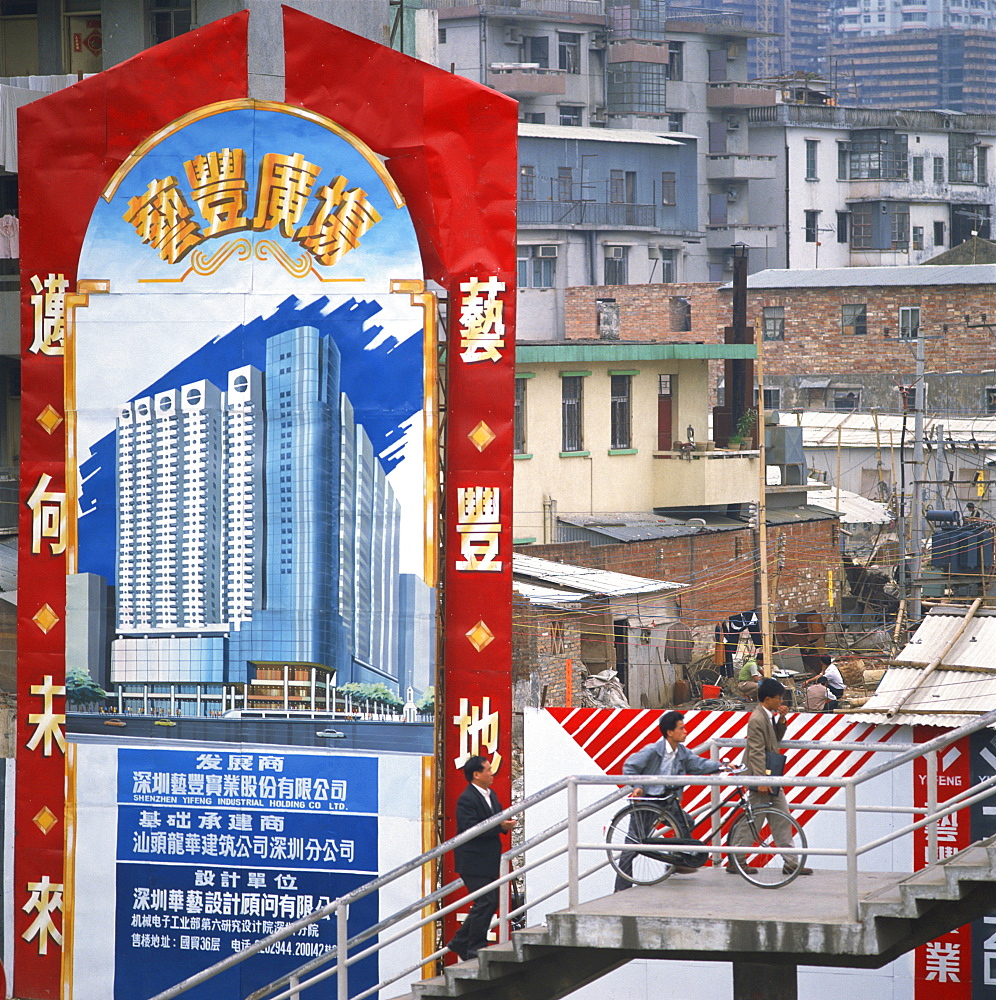 Sign showing modern buildings in front of old huts and apartment blocks in the Shenzhen Development Zone, Guangdong, China, Asia