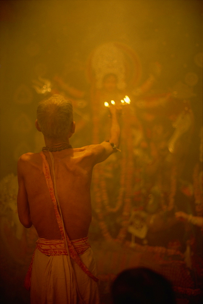 Temple priest before the image of the ten armed warrior goddess Durga, Durga Puja Festival, Varanasi, Uttar Pradesh state, India, Asia