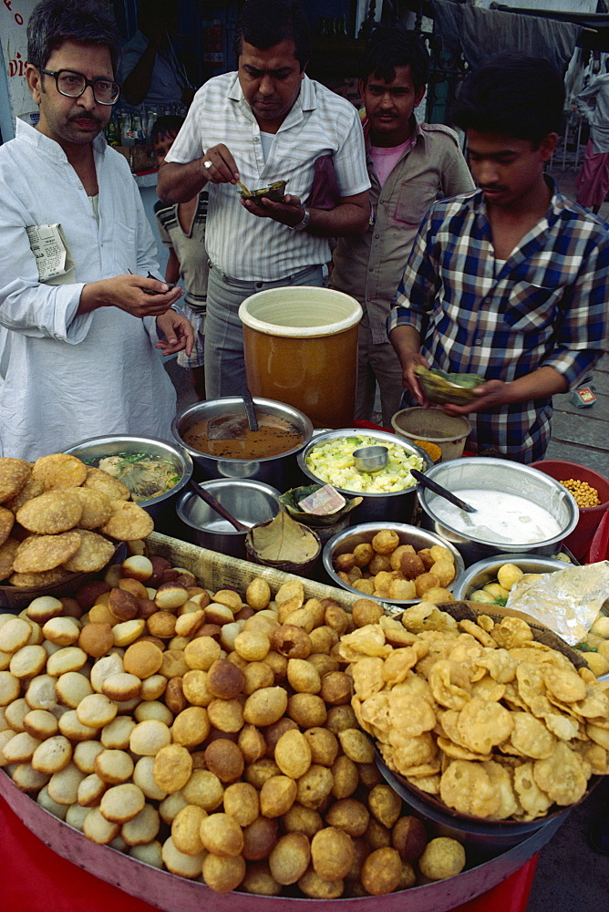 Office workers take lunchtime snack on busy street, Delhi, India, Asia