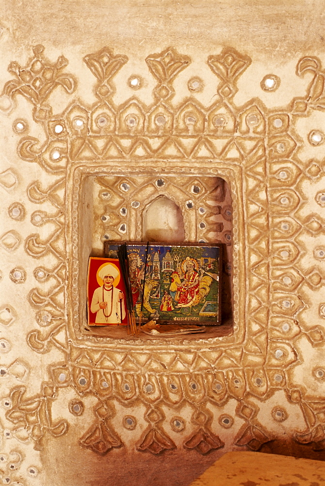 Raised mud reliefs inlaid with mirror on the walls of modern home in traditional tribal Rabari round mud hut, Bunga style, near Ahmedabad, Gujarat state, India, Asia