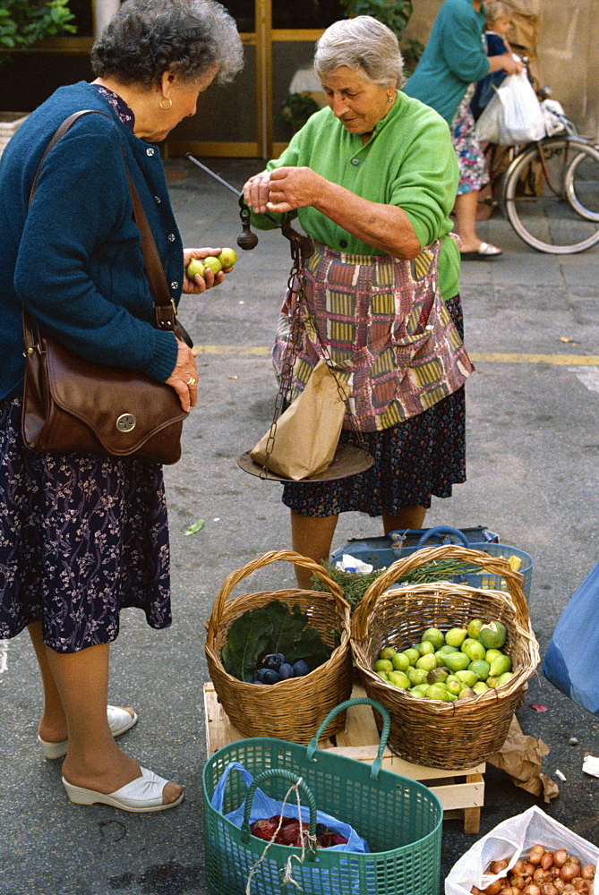 Woman selling figs with an old fashioned balance in the market at Pescia in Tuscany, Italy, Europe