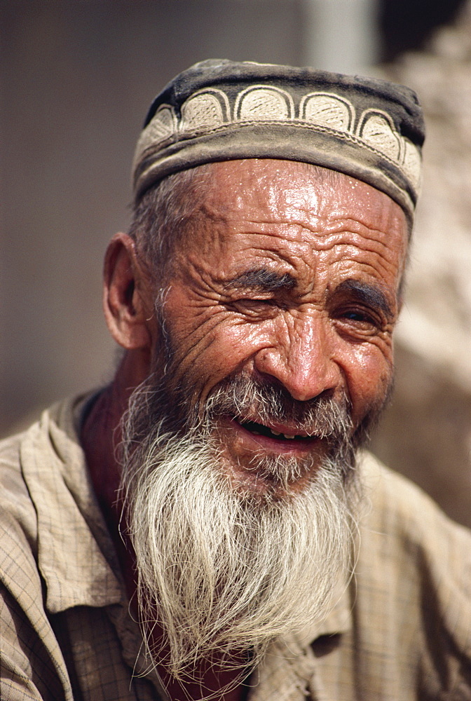 Portrait of an old Uygur man with beard and felt hat in Xinjiang, China, Asia