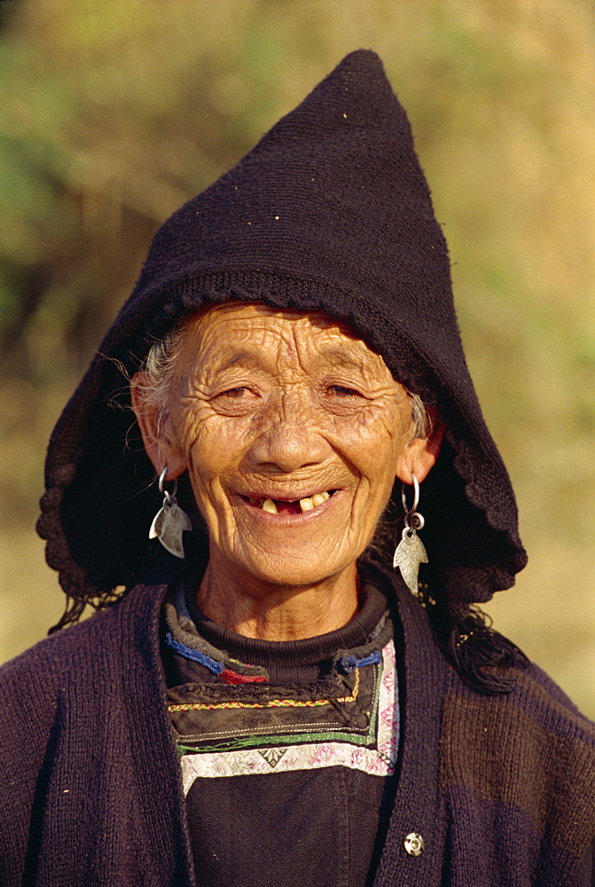 Portrait of an old Miao woman in a black woollen hood in central Guizhou, China, Asia