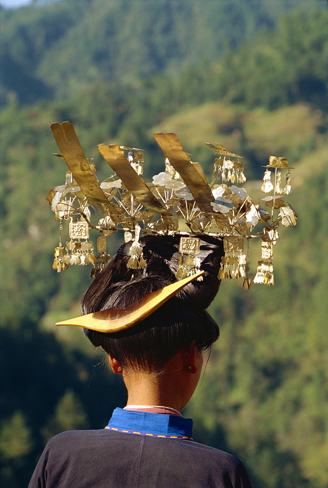 Back view of a Miao girl with head dress of silver during a festival in Guizhou Province, China, Asia