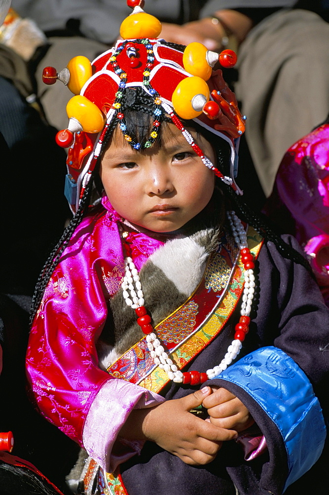 Little girl wearing traditional amber jewellery at Yushu, Qinghai Province, China, Asia