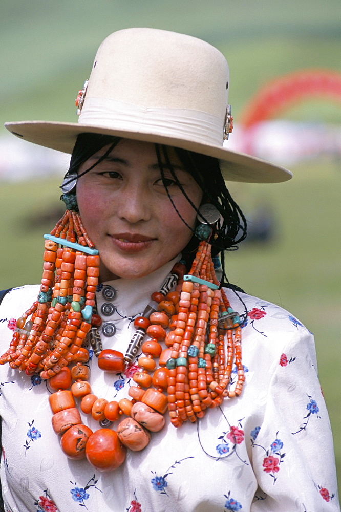 Portrait of a Tibetan woman wearing jewellery near Maqen, Qinghai Province, China, Asia