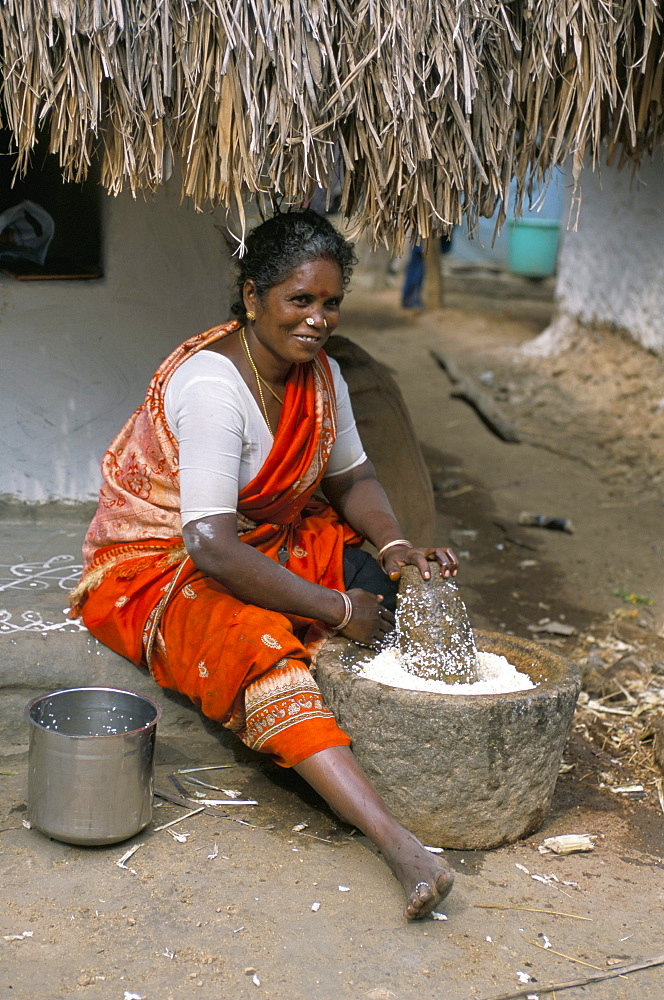 Village woman pounding rice, Tamil Nadu, India, Asia