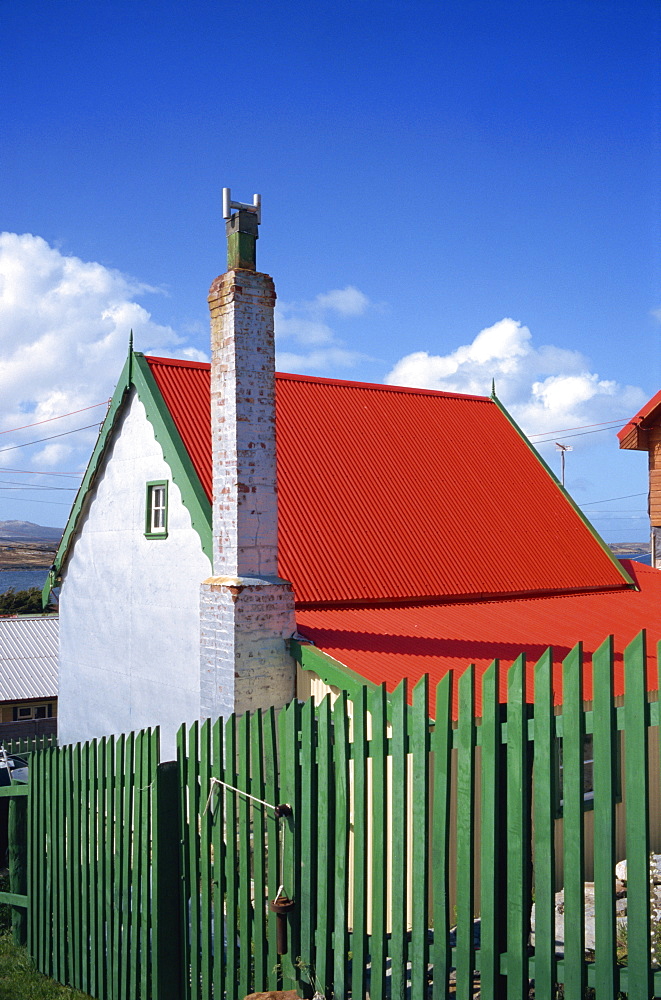 A private house with red corrugated roof and green fence in Stanley, capital of the Falkland Islands, South America