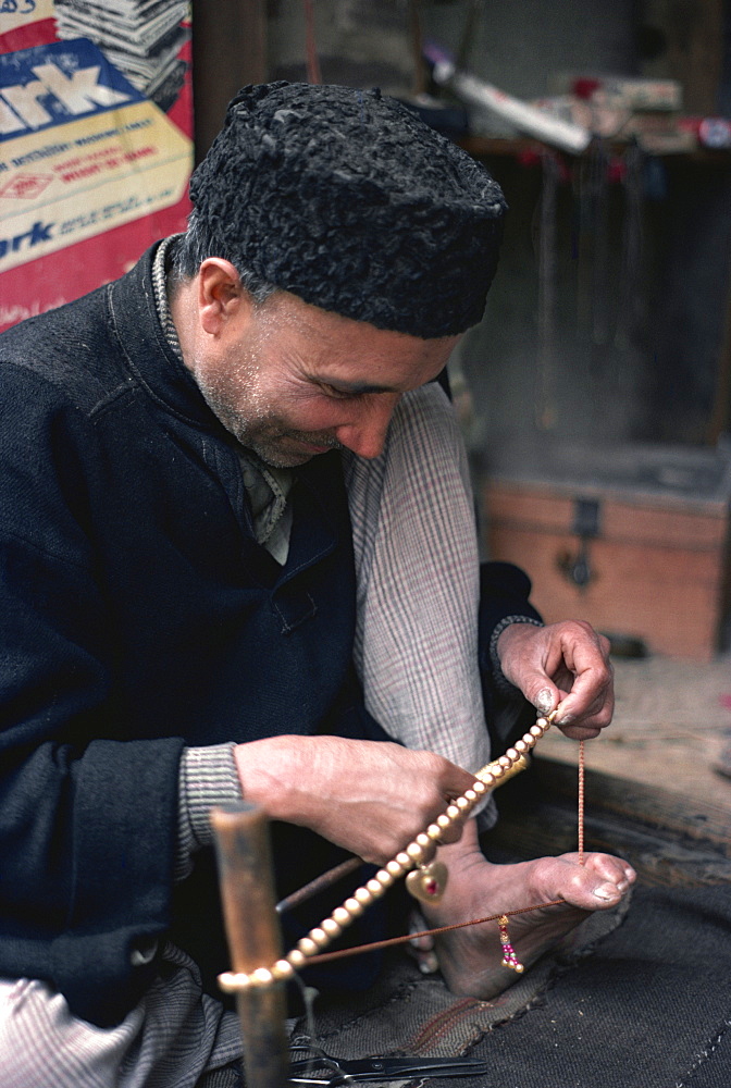 Man stringing beads, Srinagar, Kashmir, India, Asia