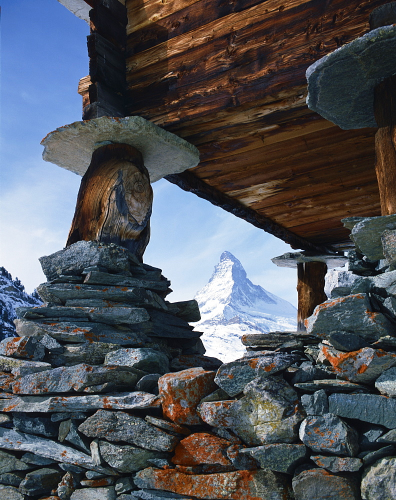 Close-up of rocks and wooden building of an old raccard at Findeln, Zermatt, with the Matterhorn in the background, in Switzerland, Europe