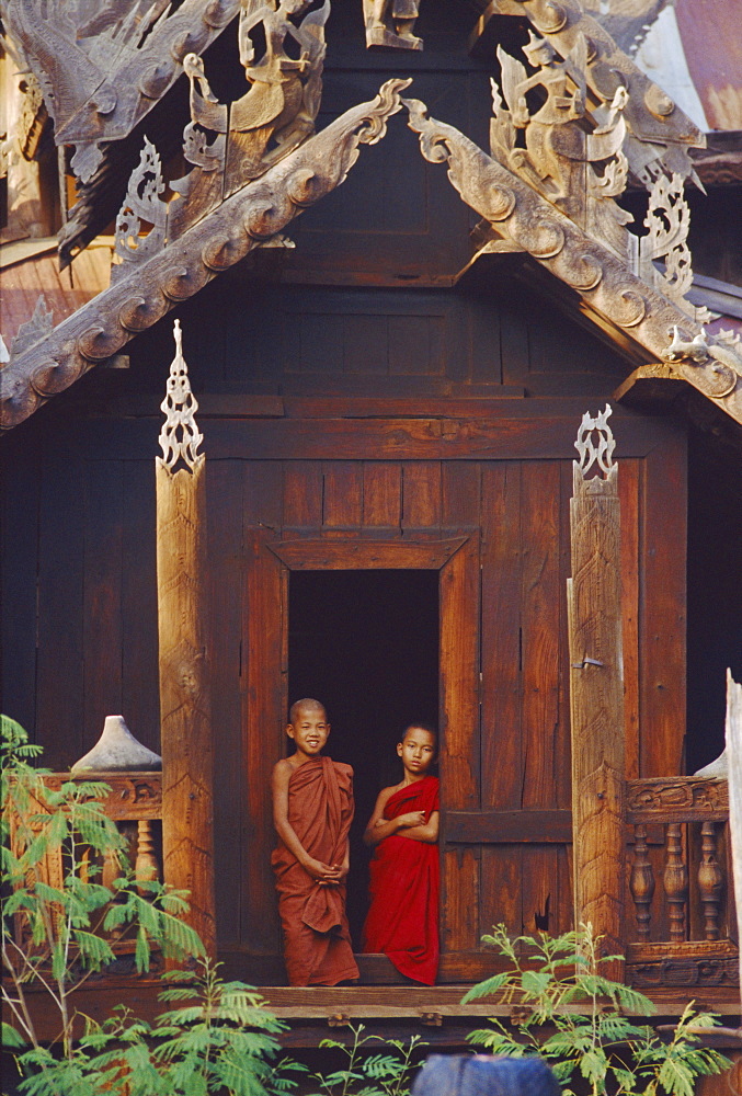 Two young monks in the door of a wooden monastery, Bagan (Pagan), Myanmar (Burma), Asia