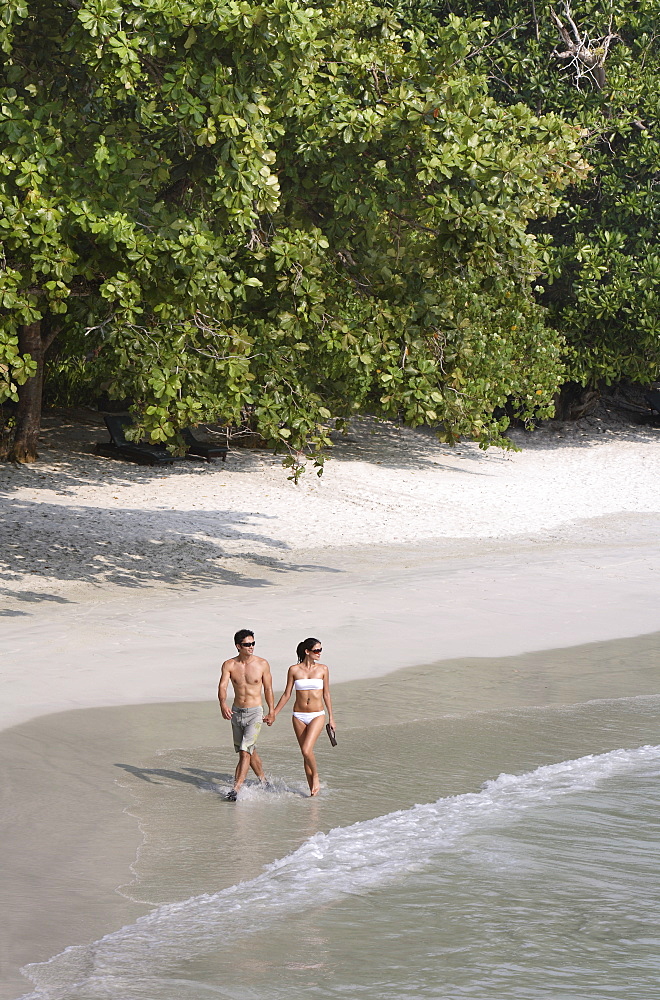 Couple walking on the beach at Emerald Bay, Pangkor Laut, Malaysia, Southeast Asia, Asia