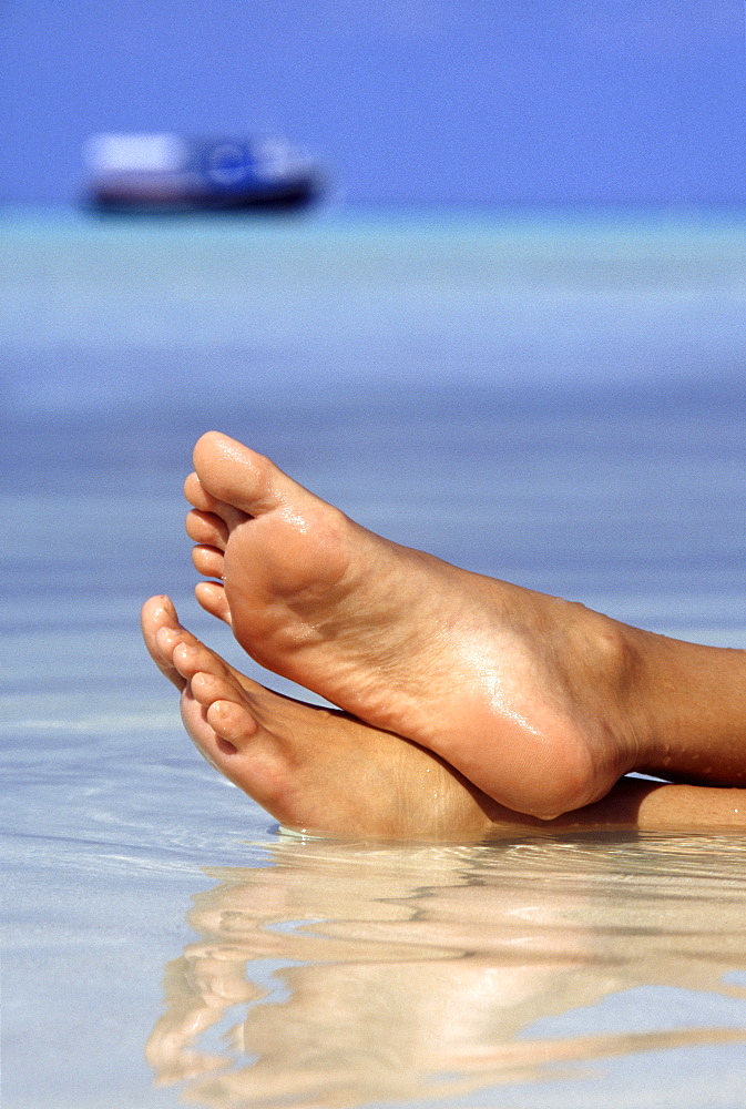 Close-up of feet on the beach