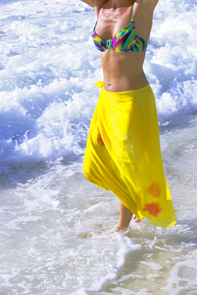 Woman standing in the surf, Grand Anse beach, La Digue Island, Seychelles, Indian Ocean, Africa