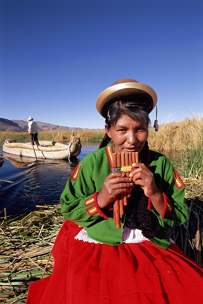 Portrait of a Uros Indian woman holding pipes, on floating reed island, Islas Flotantes, Lake Titicaca, Peru, South America