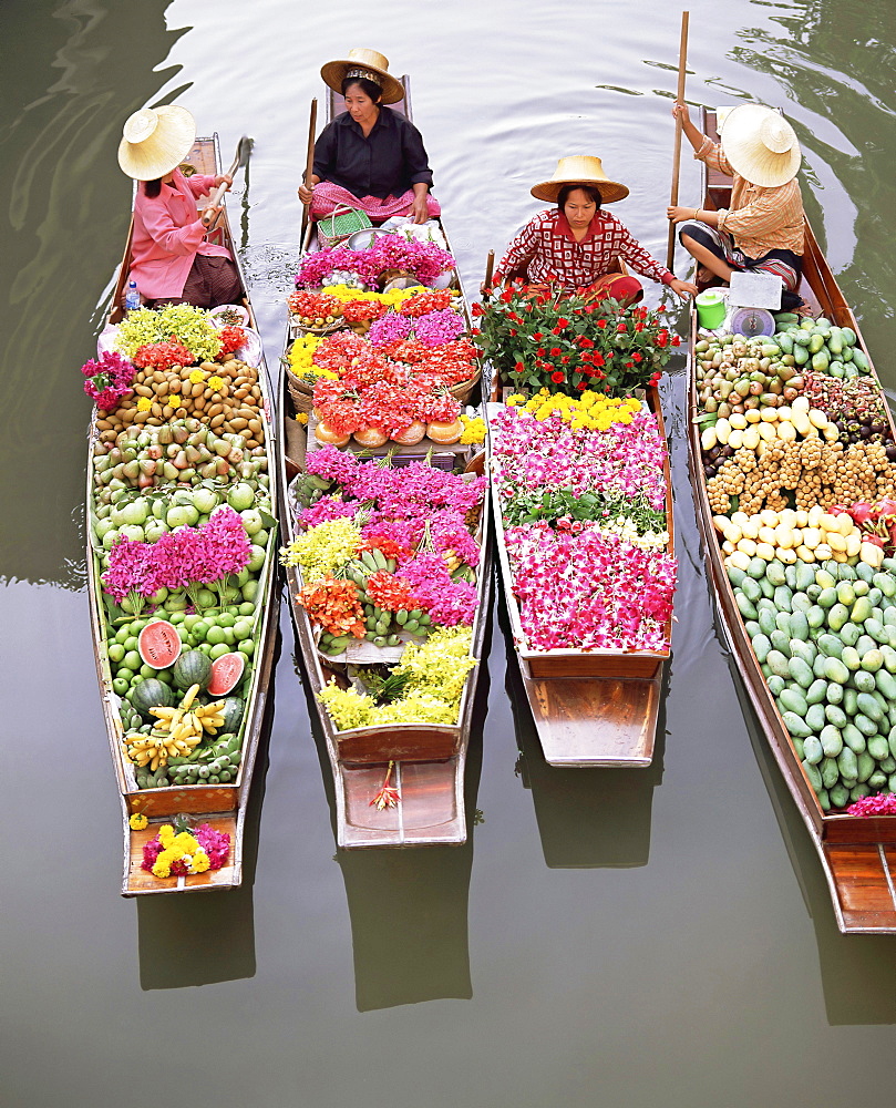 A group of four women market traders in boats laden with fruit and flowers, Damnoen Saduak floating market, Bangkok, Thailand, Southeast Asia, Asia