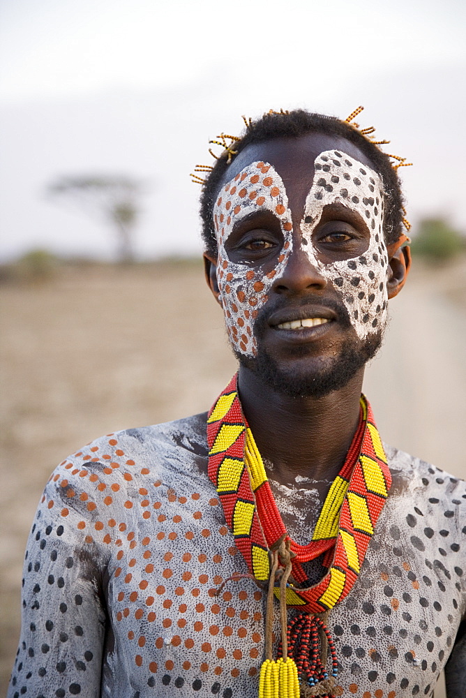 Portrait of a Karo tribesman, with face and body painted with chalk to represent the spotted plumage of the guinea fowl, Omo river, Lower Omo Valley, Ethiopia, Africa