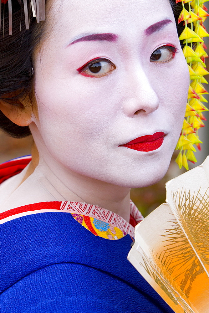 Portrait of a geisha holding a traditional paper fan, Kyoto, Kansai region, Honshu, Japan, Asia