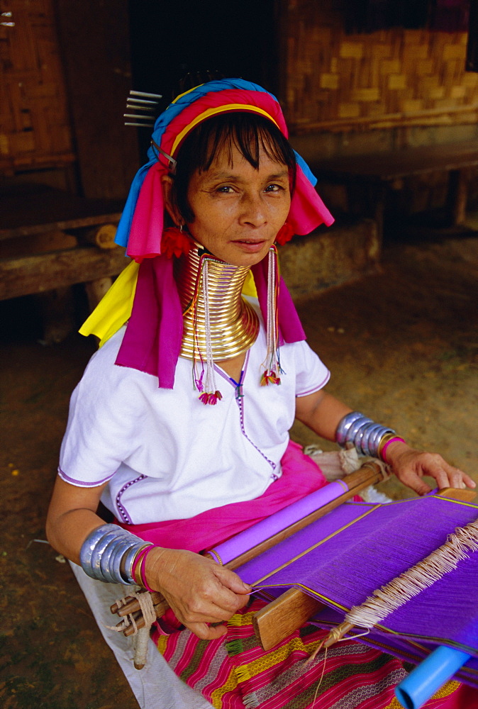 Portrait of a 'Long necked' Padaung tribe woman weaving on a hand held loom, Mae Hong Son Province, northern Thailand, Asia