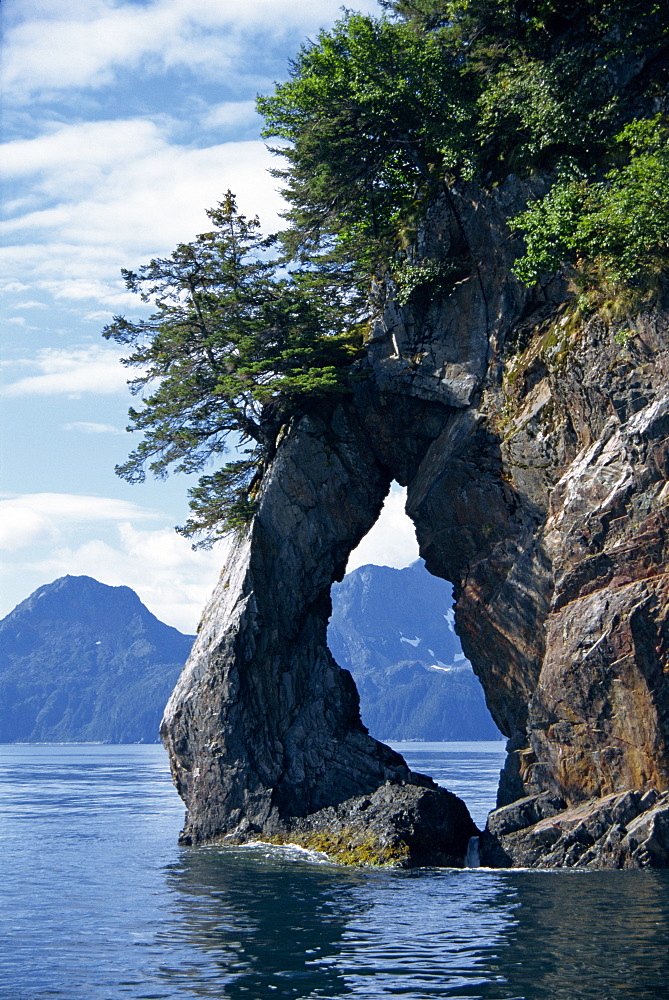 Natural arch on edge of Threehole Bay, Kenai Fjords, Aialik Peninsula, Alaska, United States of America, North America