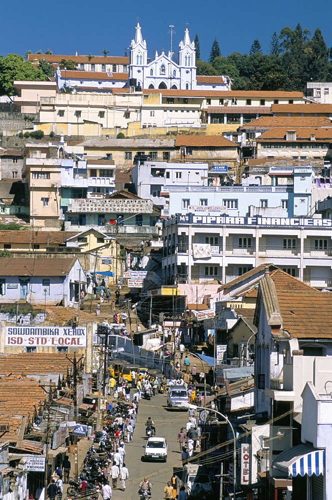 Downtown area overlooked by large Christian church in hill station of Coonor, Nilgiri Hills, Tamil Nadu, India, Asia