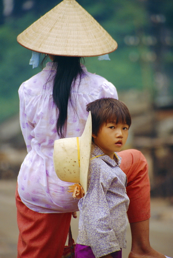 Portrait of a child and mother wearing big hats, Vietnam