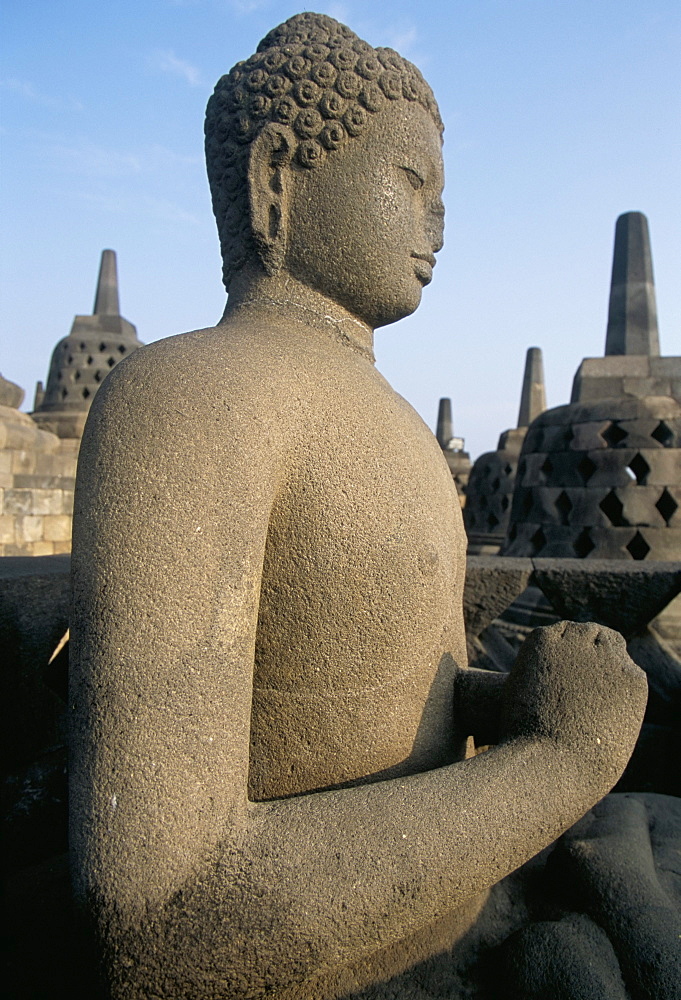 Side view of Buddha image sitting in open chamber with stupas in background, Borobudur Temple, UNESCO World Heritage Site, island of Java, Indonesia, Southeast Asia, Asia