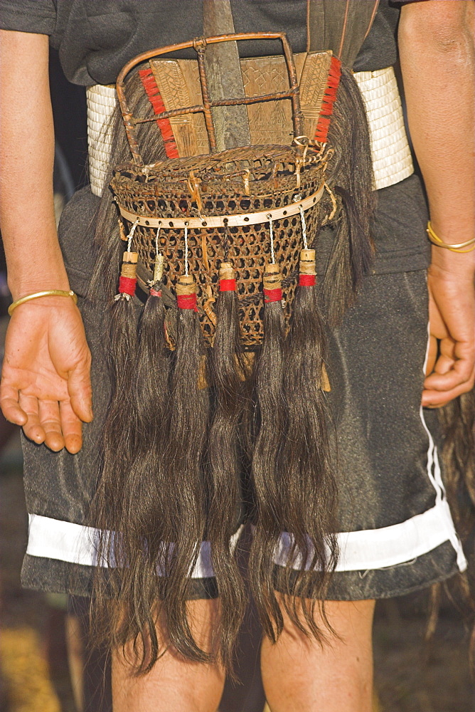 Back view of Naga man's belt with dao holder also known as Dhama (a type of machete) with ceremonial baskets with tassles of human hair, Naga New Year Festival, Lahe village, Sagaing Division, Myanmar (Burma), Asia