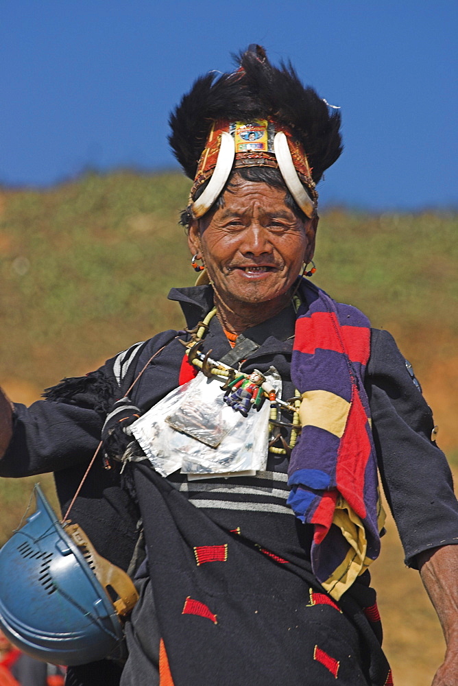 The Naga  (Macham tribe) chief of the village wearing traditional hat made of woven cane decorated with wild boars teeth and bear fur, also bead necklace with tiger teeth, Magyan Village, Sagaing Division, Myanmar (Burma), Asia