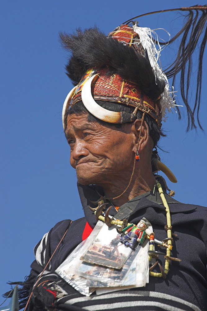 The Naga  (Macham tribe) chief of the village wearing traditional hat made of woven cane decorated with wild boars teeth and bear fur, also bead necklace with tiger teeth, Magyan Village, Sagaing Division, Myanmar (Burma), Asia