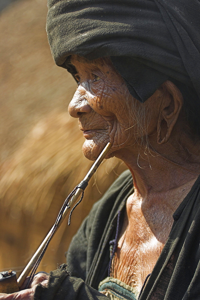 Wan Sai village (Aku tribe), old Aku lady smoking wooden pipe, Kengtung (Kyaing Tong), Shan State, Myanmar (Burma), Asia