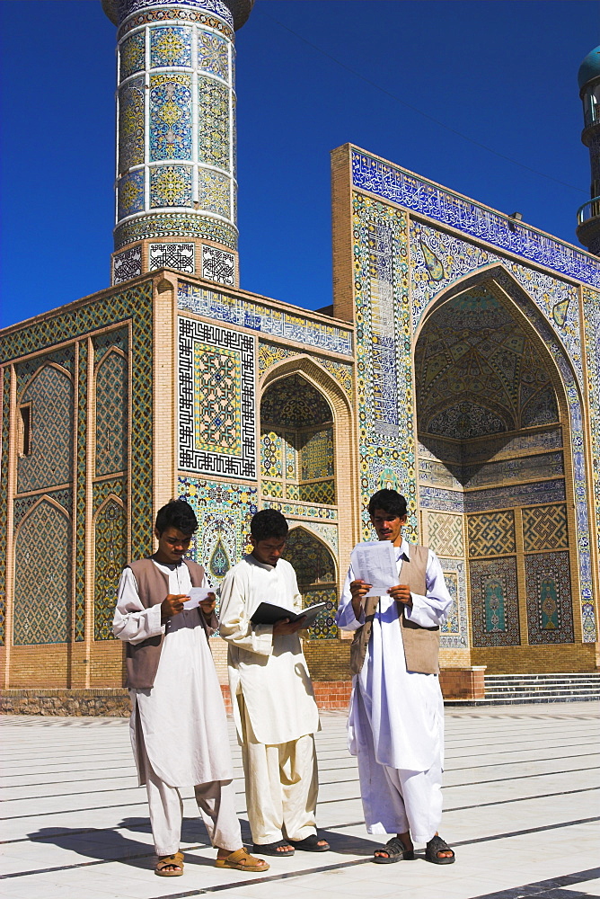 Men reading in front of the Friday Mosque or Masjet-eJam, built in the year 1200 by the Ghorid Sultan Ghiyasyddin on the site of an earlier 10th century mosque, Herat, Herat Province, Afghanistan, Asia