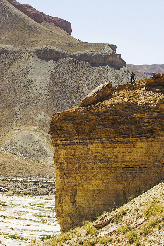 Tourist standing on rock cliff looking at Band-I-Zulfiqar the main lake, Band-E- Amir (Bandi-Amir) (Dam of the King) crater Lakes, Bamian province, Afghanistan, Asia