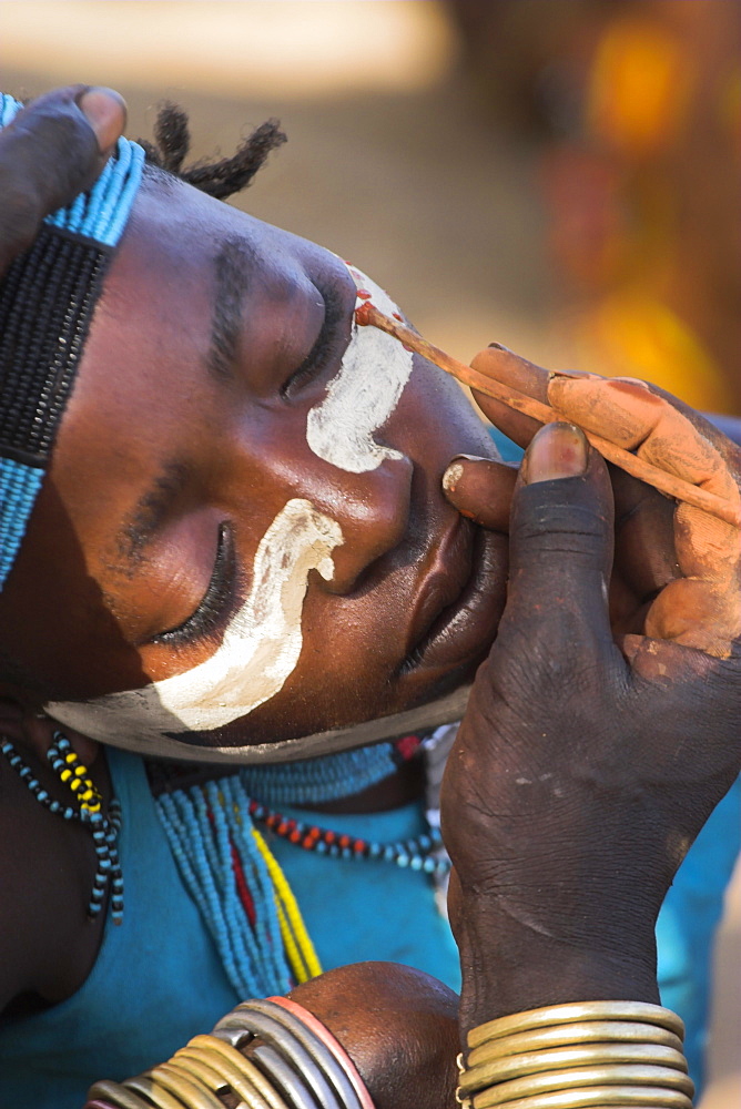 Face painting with a mixture of clay, oils and plant pigments in preparation for the Hamer (Hamar) jumping of the bulls initiation ceremony, Turmi, Lower Omo Valley, Ethiopia, Africa