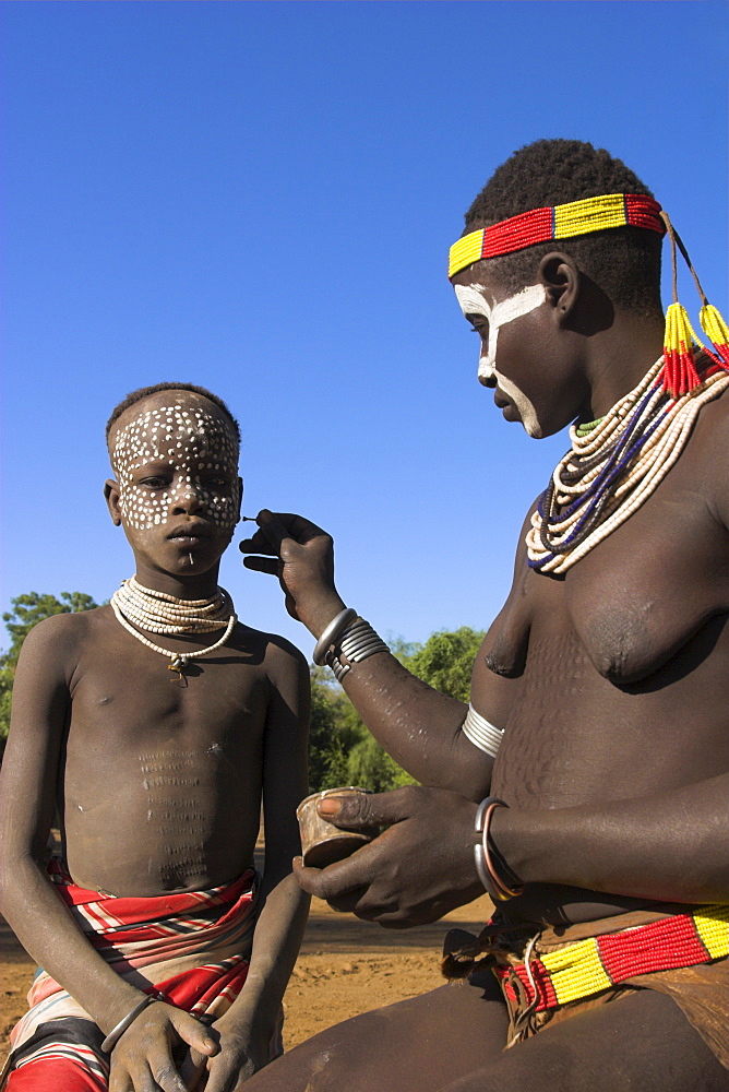 Woman painting her daughter's face, Mago National Park, Lower Omo Valley, Ethiopia, Africa