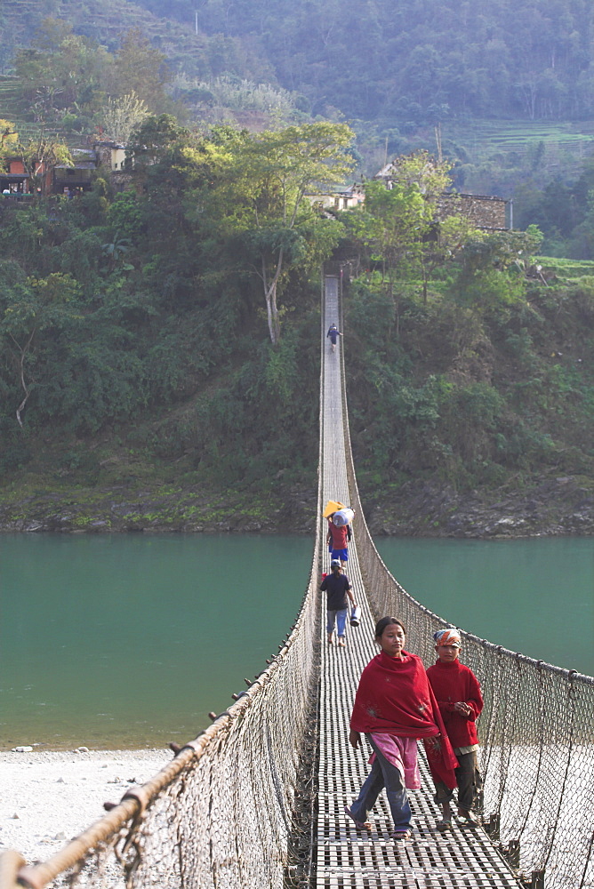 Local people crossing the 160m long suspension bridge, Trisuli Center, Bandare village, Trisuli Valley, Nepal, Asia