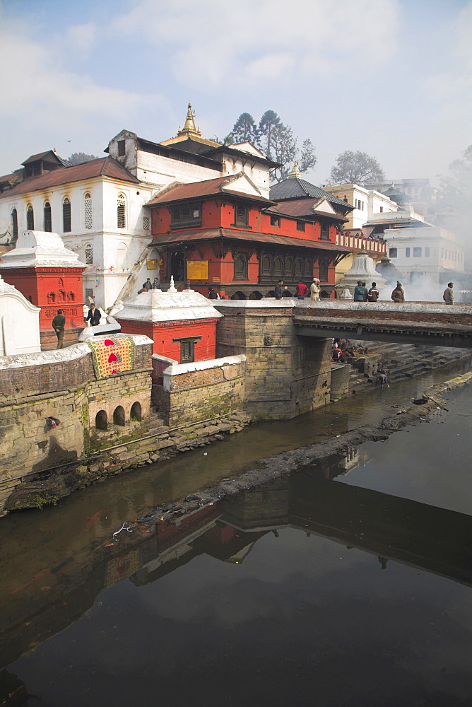 Smoke rising from cremation ceremony on banks of Bagmati River during Shivaratri festival, Pashupatinath Temple, UNESCO World Heritage Site, Kathmandu, Nepal, Asia