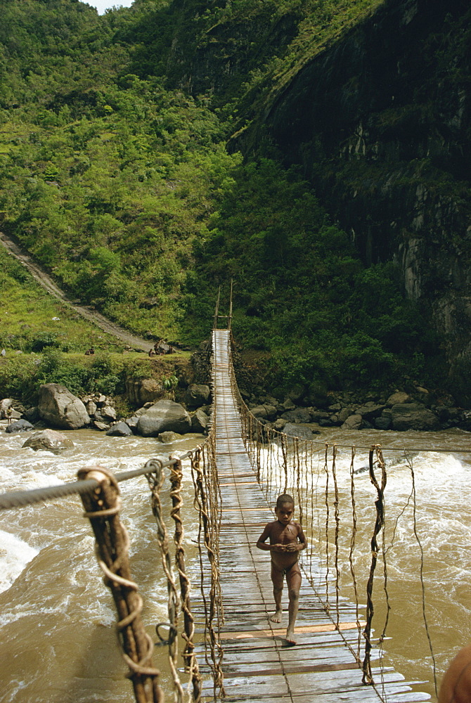 Child crossing bridge, South Beliam Valley, Irian Jaya, Indonesia, Southeast Asia, Asia