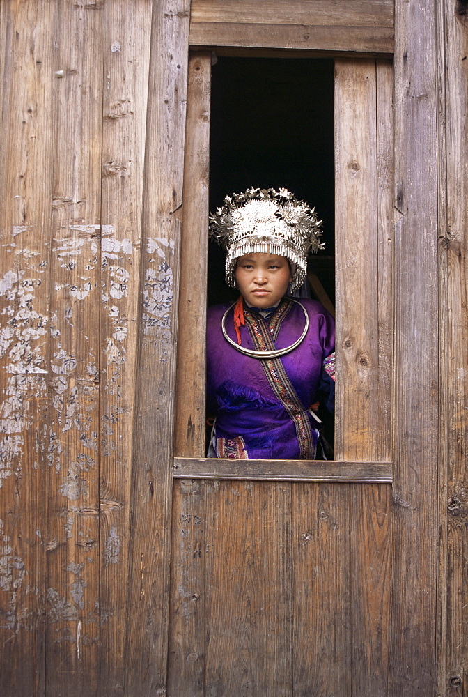 Miao woman looking out of window during festival, Langde, Guizhou province, China, Asia