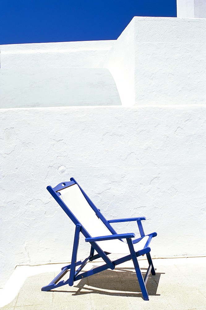 Deckchair against whitewashed wall, Imerovigli, Santorini (Thira), Cyclades Islands, Greek Islands, Greece, Europe