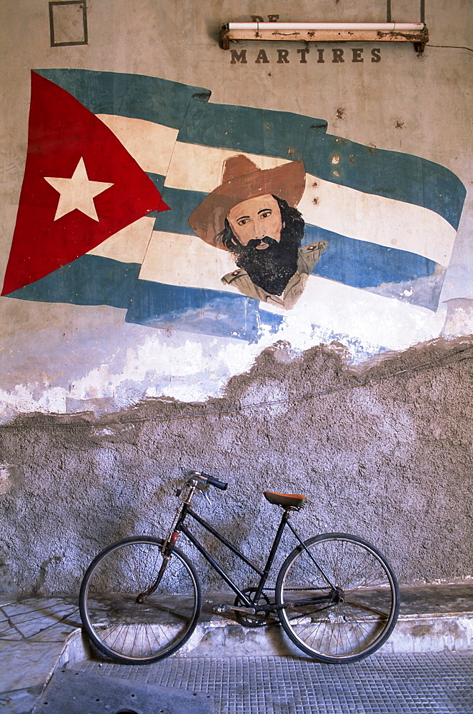 Mural of Camilo Cienfuergos on wall above a bicycle, Havana, Cuba, West Indies, Central America