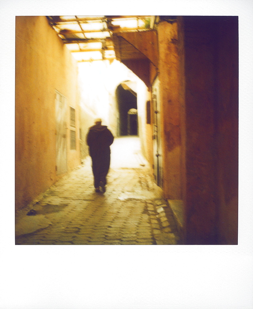 Polaroid image of man walking along narrow, dimly-lit street in the Medina, Fez, Morocco, North Africa, Africa