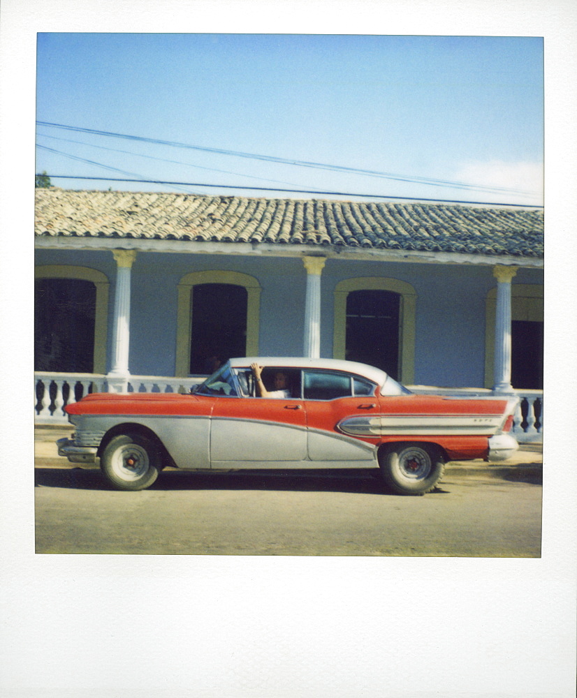 Polaroid of profile of red classic American car parked on street, Vinales, Cuba, West Indies, Central America