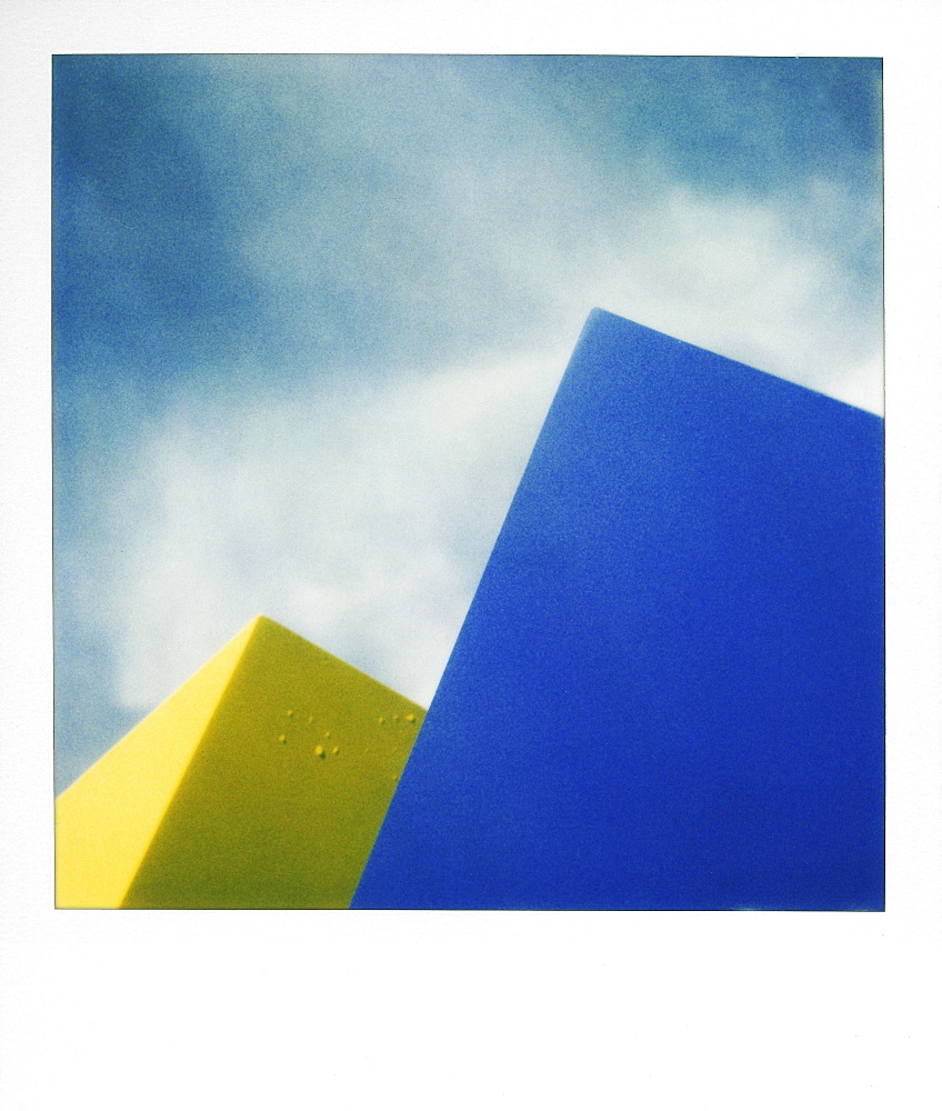 Blue and yellow shapes against sky, by Polaroid